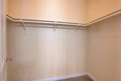 A white door with a handle is on the left side of a room with white walls and a white baseboard.