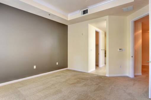 A room with a carpeted floor and a door on the right side.