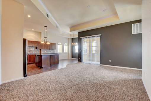 A spacious living room with a bar area and a carpeted floor.