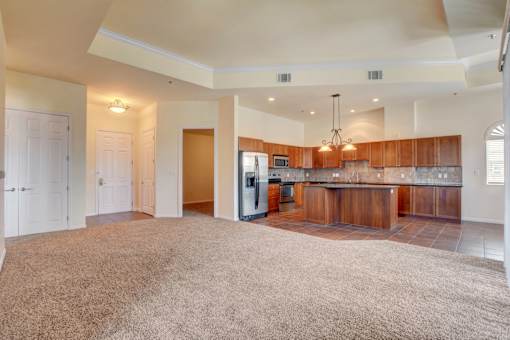 A spacious kitchen with wooden cabinets and a refrigerator.