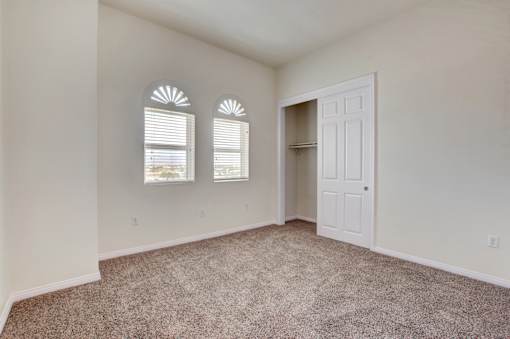 A room with a carpeted floor and a white door.
