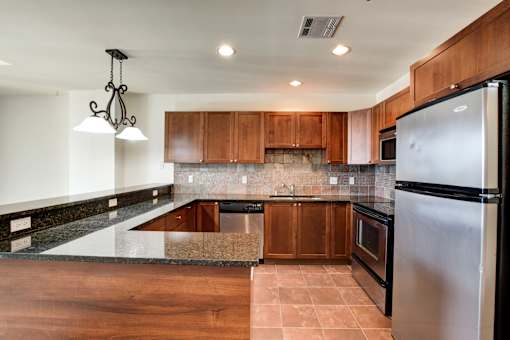 A kitchen with a refrigerator on the right side.