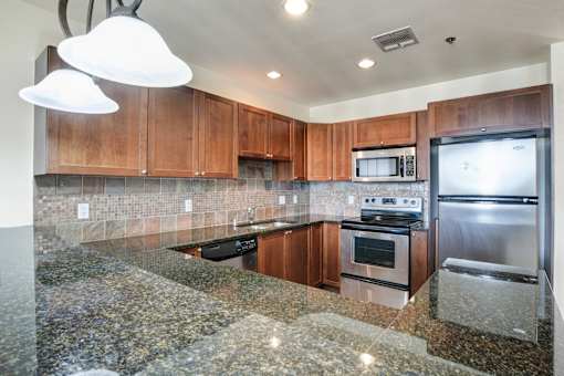 A kitchen with granite countertops and stainless steel appliances.