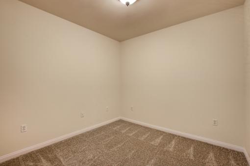 A room with a carpeted floor and a light fixture on the ceiling.