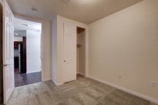 A room with a carpeted floor and two doors.