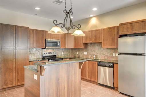 A kitchen with wooden cabinets and a granite countertop.
