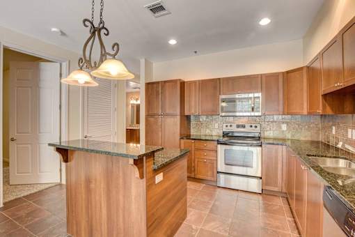 A kitchen with a wooden island and stainless steel appliances.