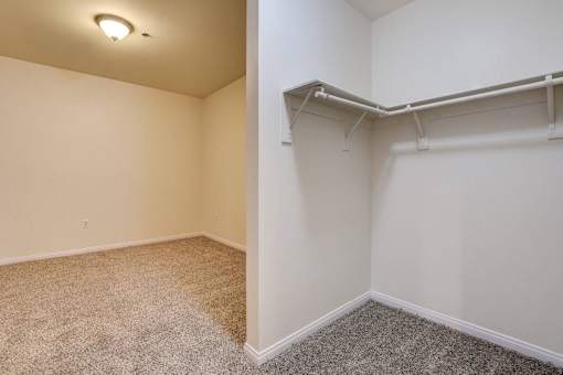 A room with a carpeted floor and a white wall with a shelf.