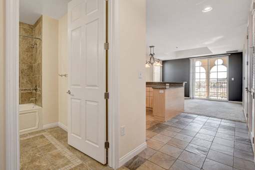 A bathroom with a walk-in shower and a white door.