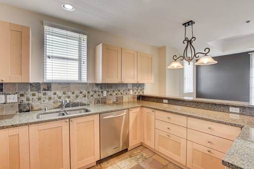 A kitchen with wooden cabinets and granite countertops.