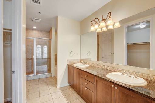 A bathroom with a double sink and a large mirror.