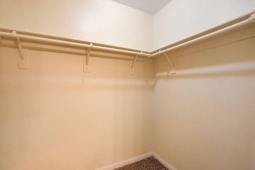 A white wall with a brown carpeted stairway.