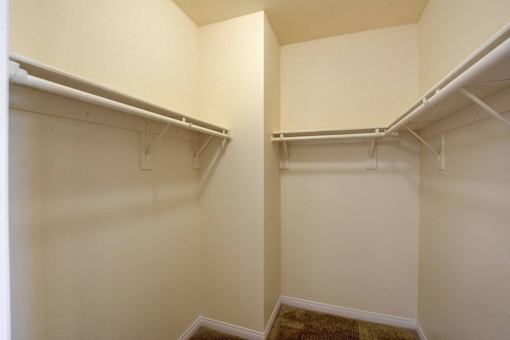 A white wall with a shelf and a white pipe.