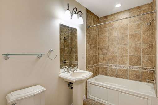 A bathroom with a white sink and a white toilet.