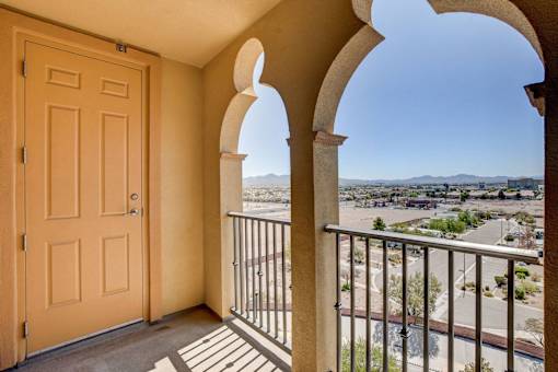 A balcony with a view of a town and mountains.