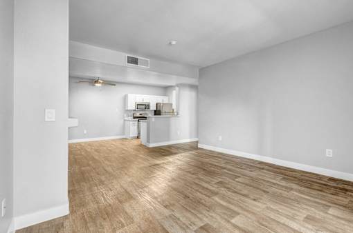A room with a kitchenette and a fan.