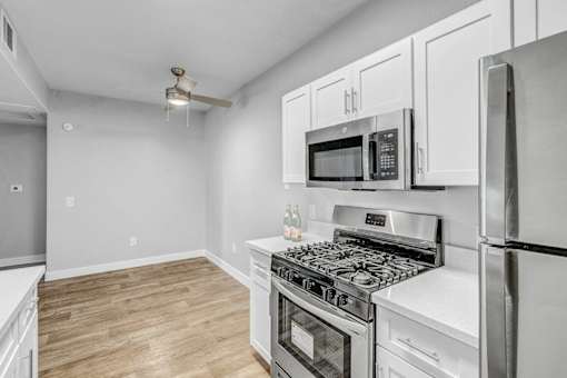 A kitchen with a stove, microwave, and refrigerator.