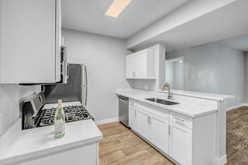 A kitchen with white cabinets and a white countertop.