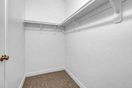A white door is on the left and a white wall with a white pipe is on the right.