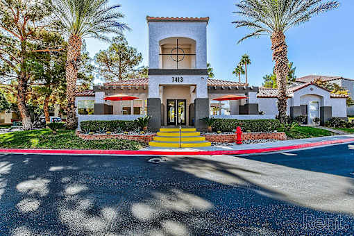 A building with the number 17413 on it is surrounded by palm trees.