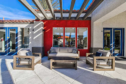 A patio with a couch, chairs, and a table.