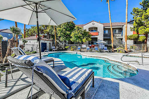 A pool with a striped cover and a sun lounger.