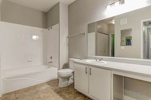 A bathroom with a toilet, sink, and bathtub.