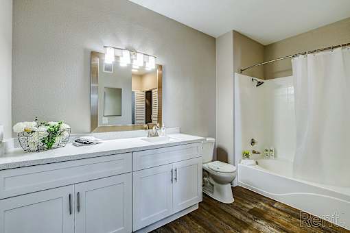 A bathroom with a white tub, sink, and toilet.