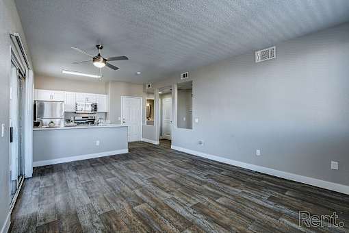 A spacious room with a ceiling fan and wooden flooring.