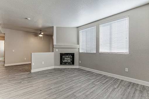 A room with a fireplace and a fan on the ceiling.