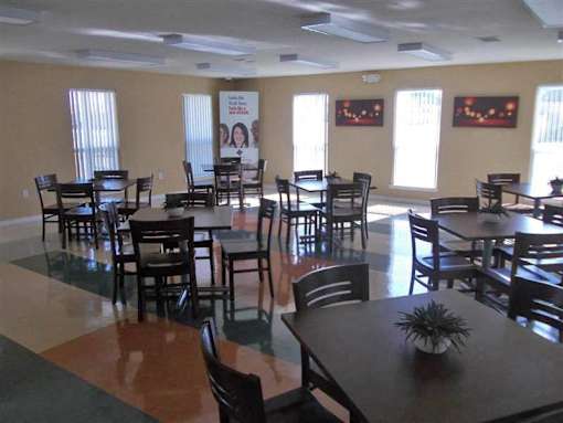 A room with tables and chairs and a poster on the wall.