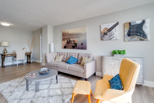Spacious apartment living area with hardwood-style flooring, natural lighting, and recessed lighting in the far corner