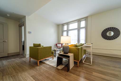 A living room with a green chair and a white table.
