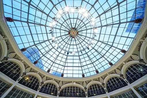 The image shows a beautiful glass dome ceiling with lights and arches.