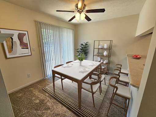 A dining room with a table set for six people.