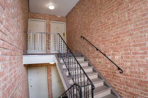 A staircase with a metal railing and a white door at the bottom.