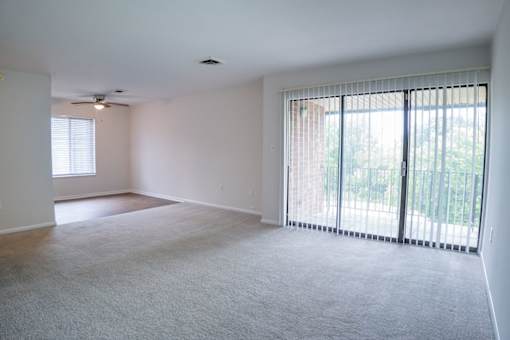 A spacious room with a carpeted floor and sliding glass doors.