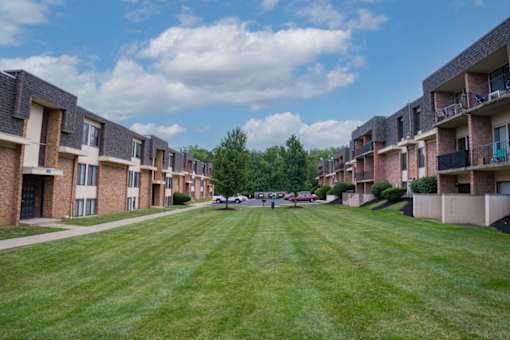 A grassy area in front of apartment buildings.