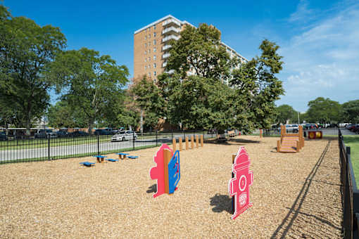 A playground with a red fire hydrant and a blue slide.