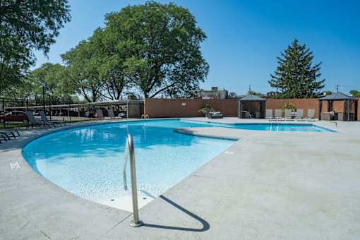 A large outdoor swimming pool surrounded by trees.