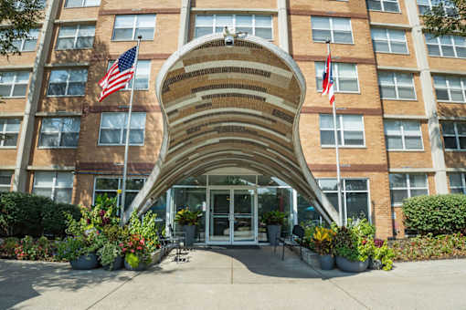A large building with a curved entrance and American flags on either side.