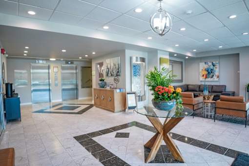 A modern office lobby with a glass table and a coffee table.