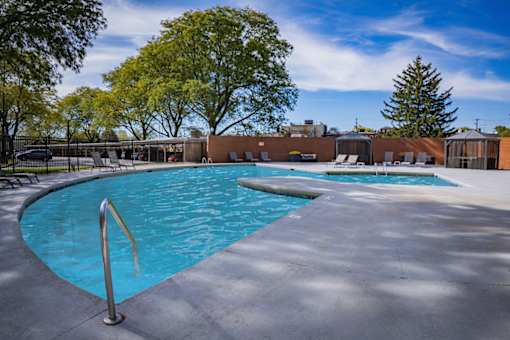 A swimming pool surrounded by trees and a fence.