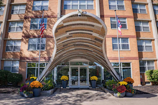 A building with a large arched entrance and American flags on either side.