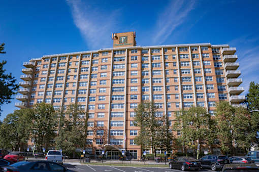 A large apartment building with a parking lot in front.