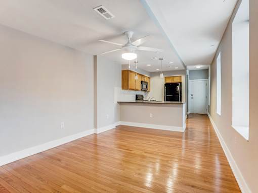A room with wooden floors and a ceiling fan.