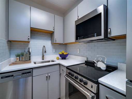 A modern kitchen with a black microwave above the stove.