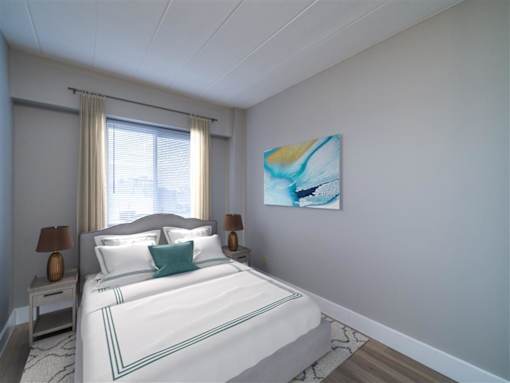 A bedroom with a large bed and a painting on the wall.