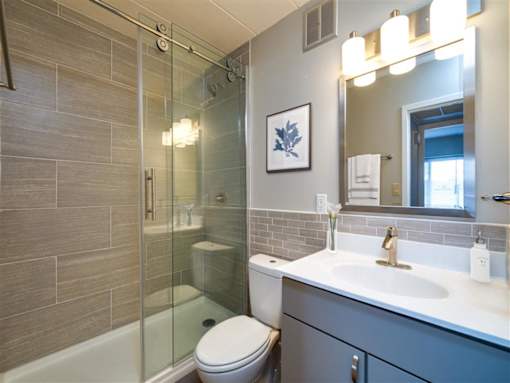 A modern bathroom with a glass shower stall and a white toilet.