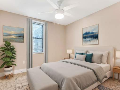A bedroom with a large bed, a ceiling fan, and a painting on the wall.